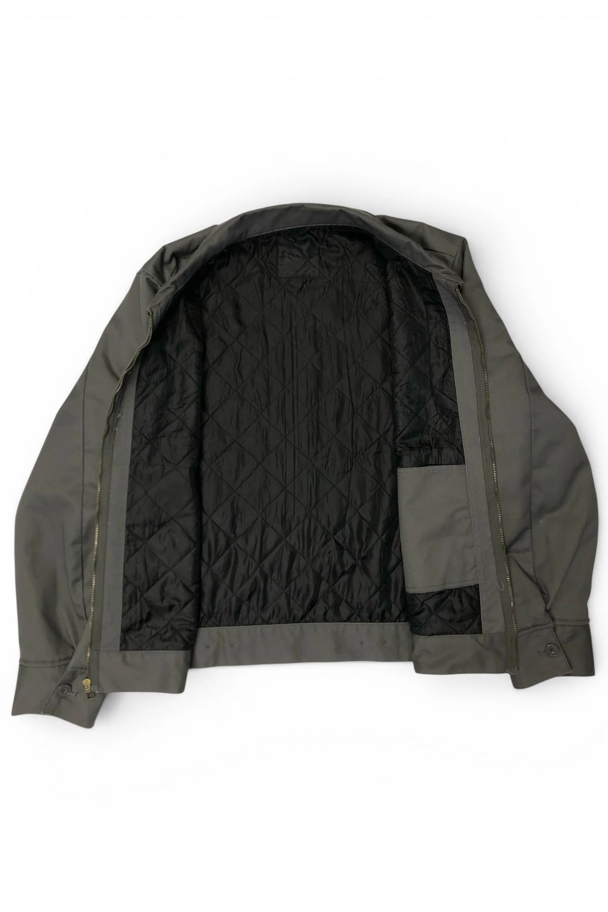 Interior view of the Common Saints dark gray mechanic jacket with black diamond-quilted lining and inner patch pocket