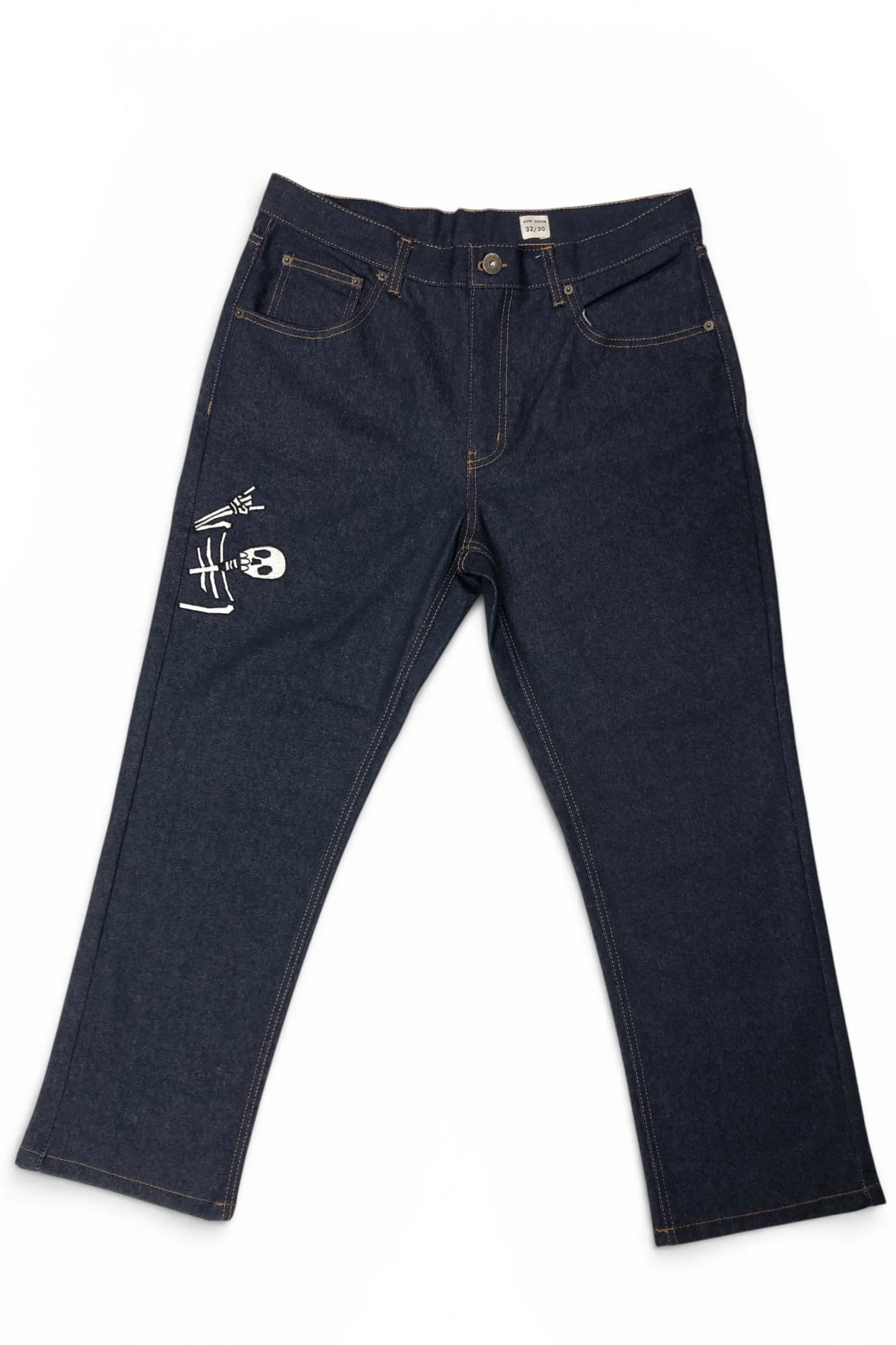 Front view of Common Saints dark indigo denim jeans with five-pocket styling, contrast stitching, and white skull graphic on the left thigh